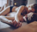 Pareja en la cama tomados de la mano